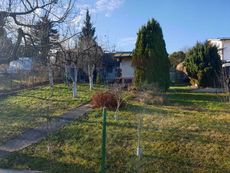 Eine Hütte im Garten in Mojšova Lúčka in Žilina, umgeben von Bäumen und Grün.