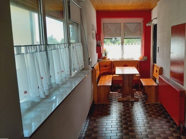 Einfamilienhaus mit Holzecke in der Küche, roten Wänden und gefliestem Boden.