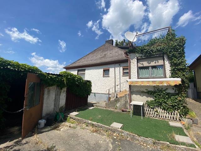 Einfamilienhaus in Hundsheim mit weißer Fassade, Terrasse und Gartenbereich.