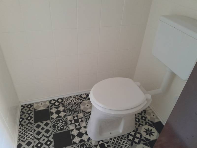 Toilette mit Keramikboden in Geschäftsräumen.