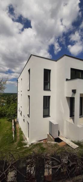 Weiße Fassade der Villa in Hainburg an der Donau mit modernen schwarzen Fenstern.