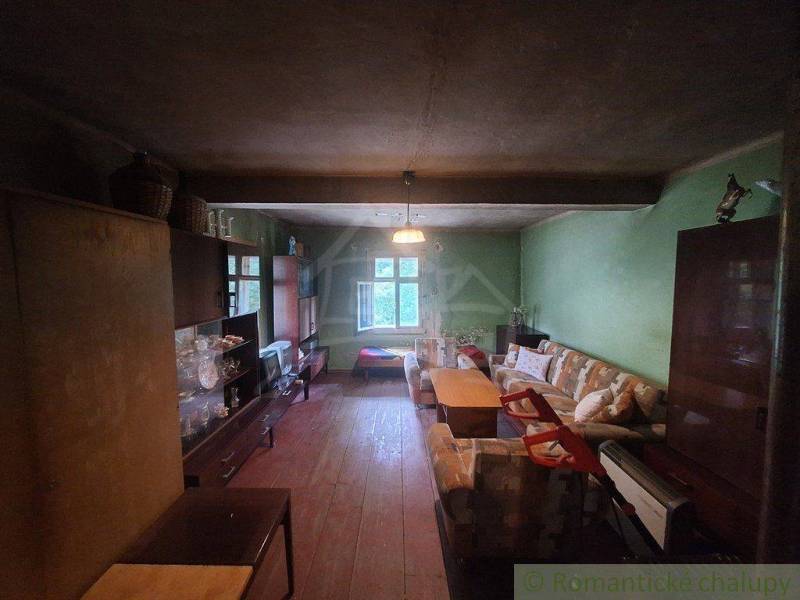 Rustikales Interieur einer Hütte mit Möbeln und einem Sofa in einem gemütlichen Raum.