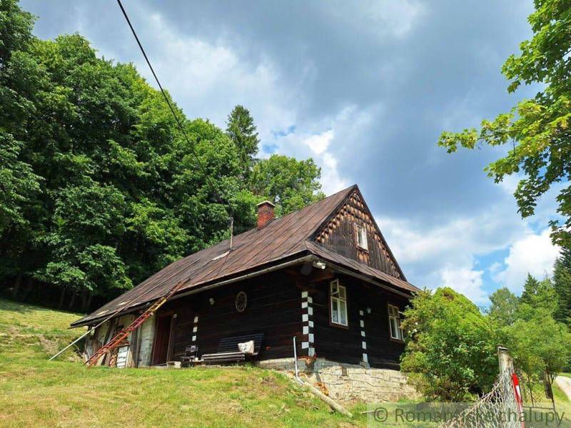 Eine Hütte in Zákopčí, umgeben von Wäldern und schöner Natur unter einem bewölkten Himmel.