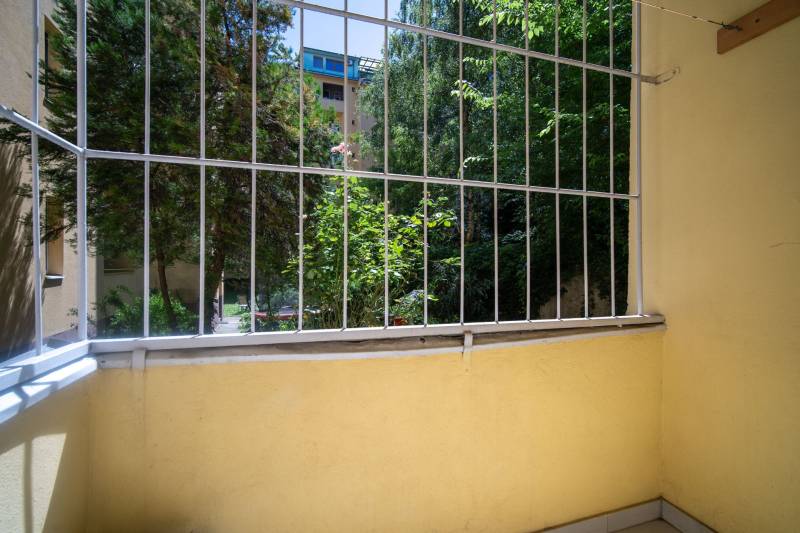 Ein kleiner Balkon mit Blick ins Grüne und Holzelemente in einer 3-Zimmer-Wohnung.
