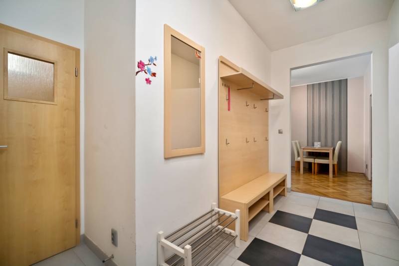 Flur mit Garderobenwand und Schuhschrank in einer 3-Zimmer-Wohnung, der ins Esszimmer führt.