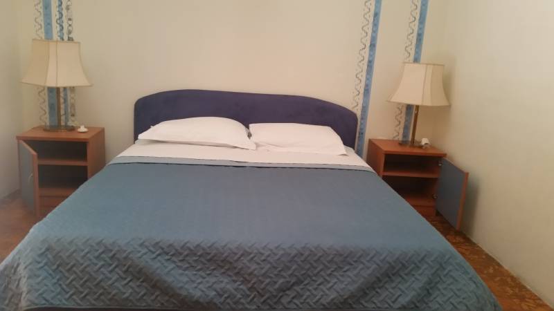 Schlafzimmer im Einfamilienhaus mit Doppelbett und Nachttischen.
