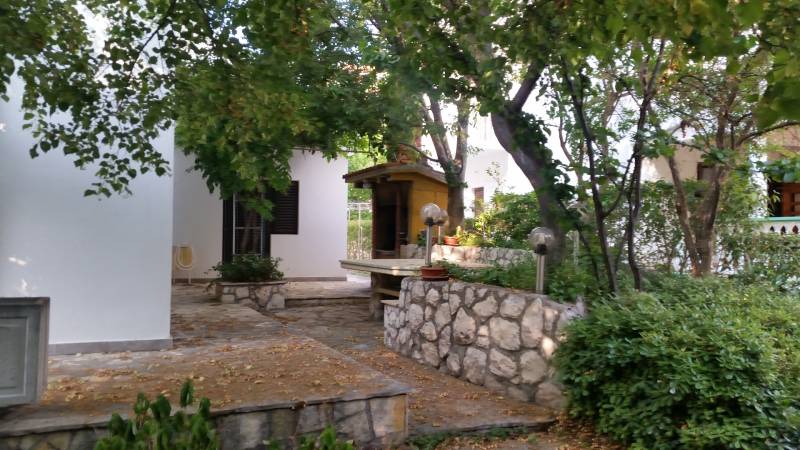 Ein Einfamilienhaus in Vrsi, umgeben von Bäumen und Steinelementen.