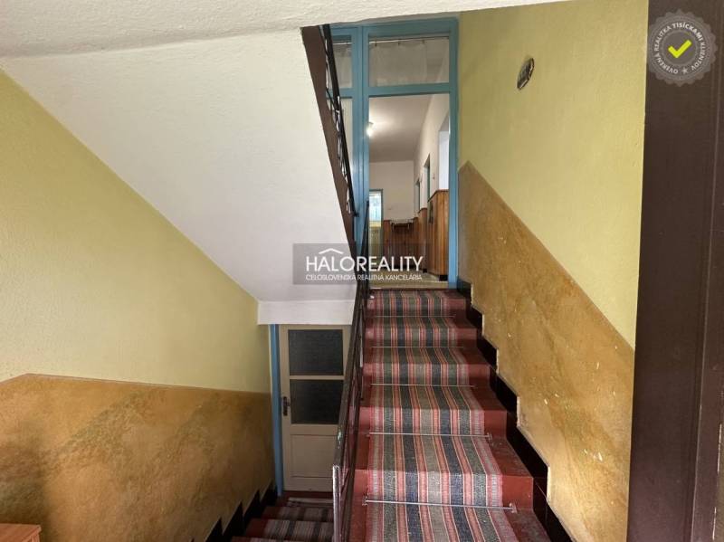 Eine Küche in einem Einfamilienhaus mit Holzmöbeln, einer Mikrowelle und einem dekorierten Kühlschrank.