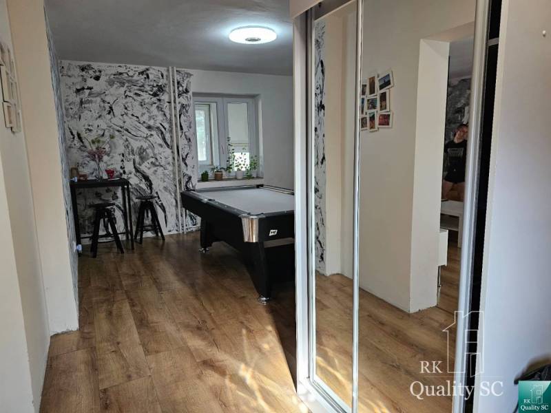 Innenraum eines Einfamilienhauses mit Billardtisch, Tisch und Stühlen, Holzboden.