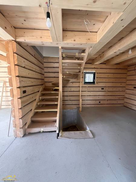 Holzinterieur der Hütte mit Betonboden und Treppe.