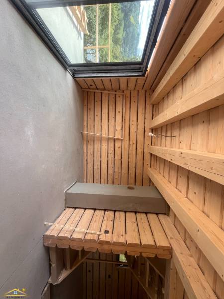Holzinterieur in einer Hütte mit Blick auf die Natur durch ein großes Fenster.