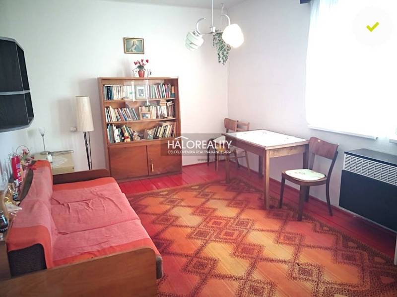 Obývacia izba v rodinnom dome so sedacou súpravou a knihovničkou.