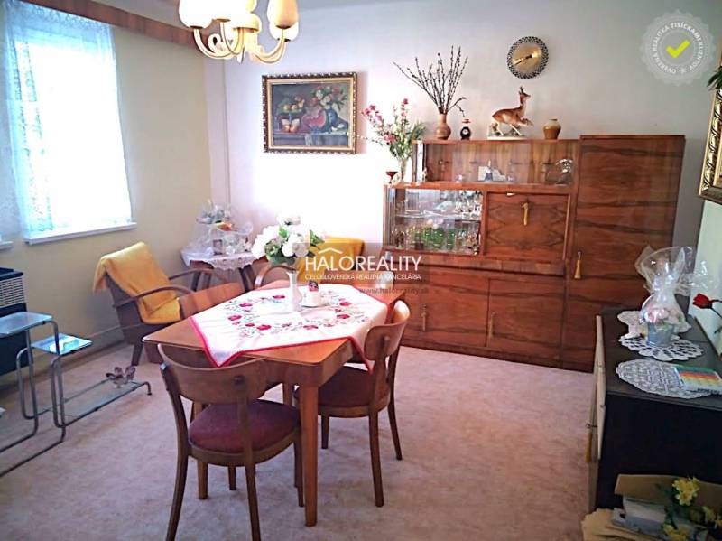 Innenraum in einem Einfamilienhaus, Esszimmer mit Retro-Möbeln, Fenster, Blumen, Tischdecke, Sessel.