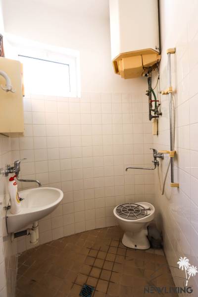Badezimmer in Geschäftsräumen mit Dusche, Waschbecken und Fenster.