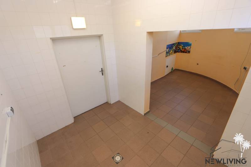Ein gefliester Raum mit einer Öffnung in den angrenzenden Bereich, Geschäftsräume mit Fliesen.