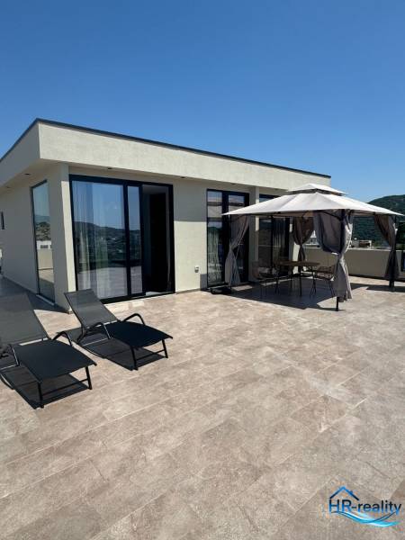Ferienwohnung in Ksamil mit Terrasse, Liegestühlen und Gartenpavillon zur Erholung.