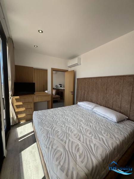 Schlafzimmer im Ferienapartment mit Doppelbett, Einbauschrank und Klimaanlage.