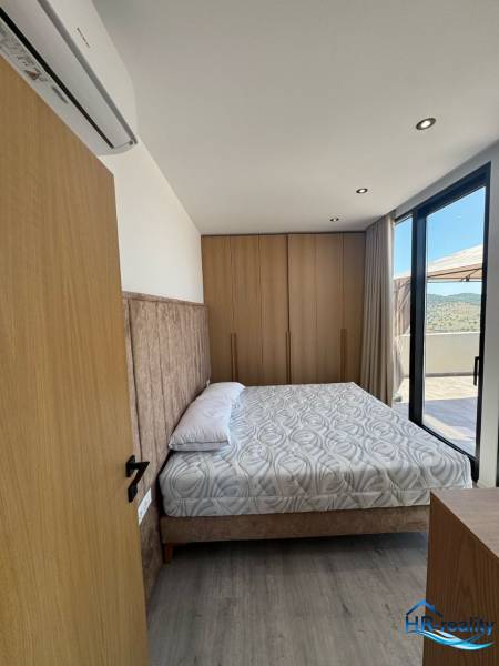Schlafzimmer in der Ferienwohnung mit bequemem Bett, stilvoller Einrichtung und Balkon.