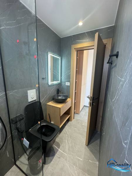 Ein Badezimmer in einer Ferienwohnung mit schwarzen Sanitäreinrichtungen und Holzmöbeln.