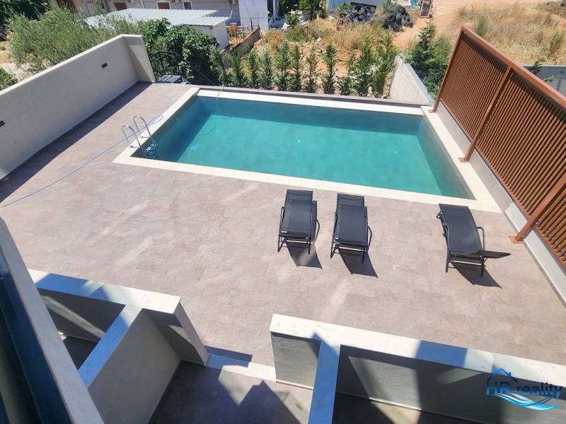 Ferienwohnung in Ksamil mit Pool und Liegestühlen auf der Sonnenterrasse.