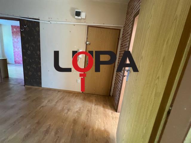 In der 3-Zimmer-Wohnung sind der Holzboden, die Türen und die Wand mit Tapete sichtbar.