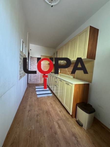 Schmale Küchenzeile mit Schränken und Bodenbelag in einer 3-Zimmer-Wohnung.