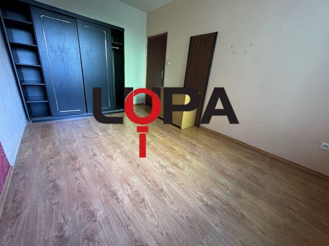 Leerer Raum mit Holzboden und Einbauschrank in einer 3-Zimmer-Wohnung.