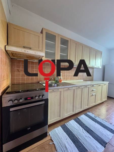 Küche mit Holzküchenzeile und Geräten in einer 3-Zimmer-Wohnung.