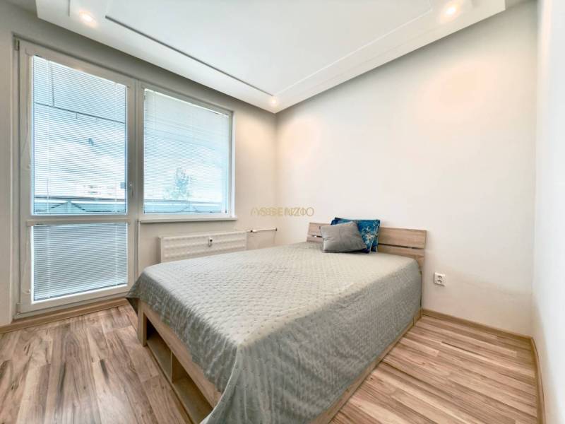 Helles Schlafzimmer in einer 4-Zimmer-Wohnung mit Laminatboden und einfachem Bett.