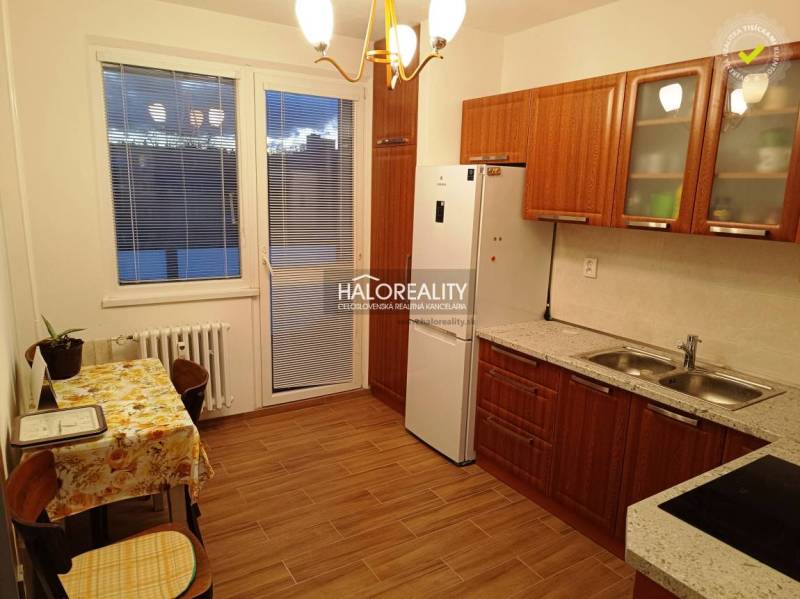 Küche und Raum in einer 2-Zimmer-Wohnung mit Holzküchenzeile und Tisch.