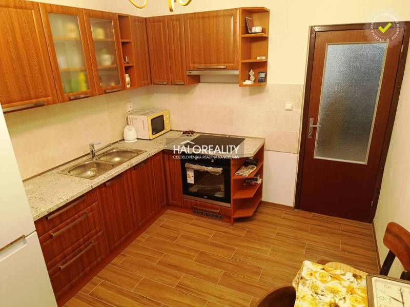 Eine Küche mit Holzschränken und Geräten in einer 2-Zimmer-Wohnung, optimal zum Kochen.