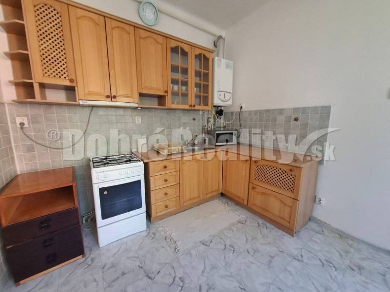Küche mit Holzschränken und Herd, Teil einer 3-Zimmer-Wohnung.