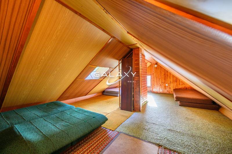 Dachboden in einer Hütte mit Holzwänden und ausziehbaren Sofas.