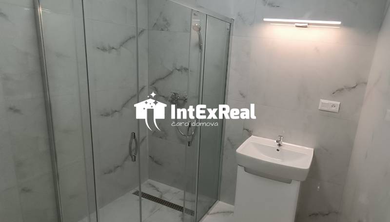 Badezimmer mit verglaster Duschkabine in einer 2-Zimmer-Wohnung.