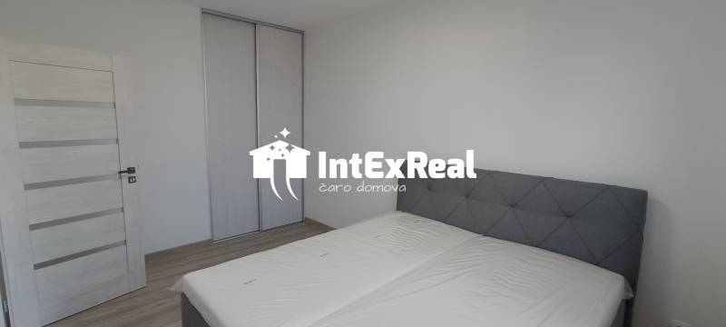 Schlafzimmer mit Doppelbett und Kleiderschrank in einer 2-Zimmer-Wohnung.