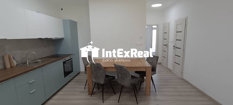 Küche und Esszimmer mit einem Holztisch und vier Stühlen in einer 2-Zimmer-Wohnung.