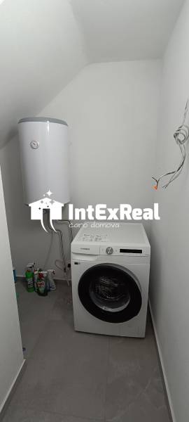 Waschküche in einer 2-Zimmer-Wohnung mit Waschmaschine und Boiler.