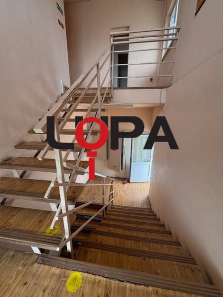 Eine Treppe im Gebäude mit Holzboden und Metallgeländer.
