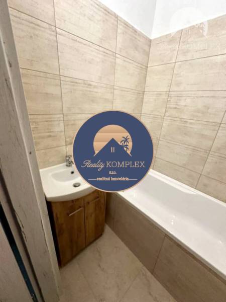 Badezimmer in einer 2-Zimmer-Wohnung mit Badewanne und Waschbecken in Holzdekor.