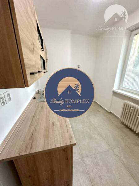 Küche mit Holzküchenzeile in einer 2-Zimmer-Wohnung, sichtbar sind auch der Heizkörper und das Fenster.