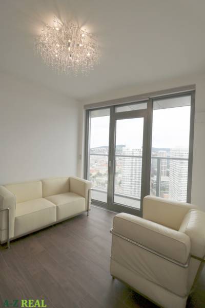 Wohnzimmer mit Ledersofas und großen Fenstern in einer 3-Zimmer-Wohnung.