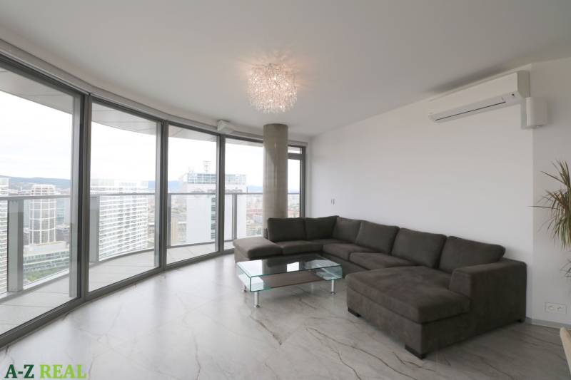 Helles Wohnzimmer in einer 3-Zimmer-Wohnung mit Ecksofa, verglasten Wänden und Blick auf die Stadt.