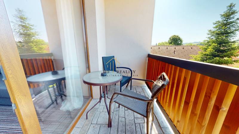 Ein Balkon in einer 2-Zimmer-Wohnung mit Blick auf die umliegende Natur und Dächer.
