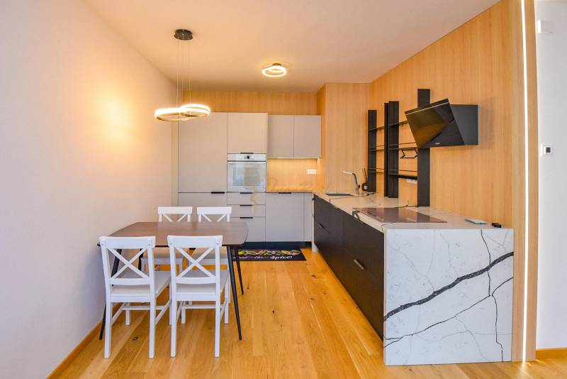 Küche in einer 3-Zimmer-Wohnung, Holzboden, Esstisch für vier Personen.