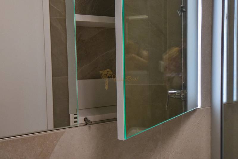 Badezimmer mit Spiegel und offenem Schrank in einer 3-Zimmer-Wohnung.