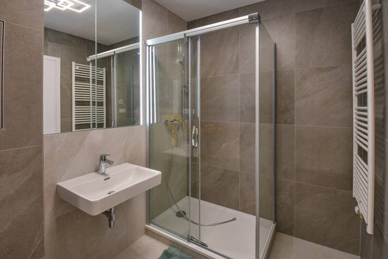 Badezimmer mit Dusche und Spiegel in einer 3-Zimmer-Wohnung.