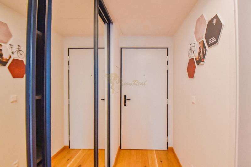 Ein Flur mit Spiegeltüren und Holzboden in einer 3-Zimmer-Wohnung.