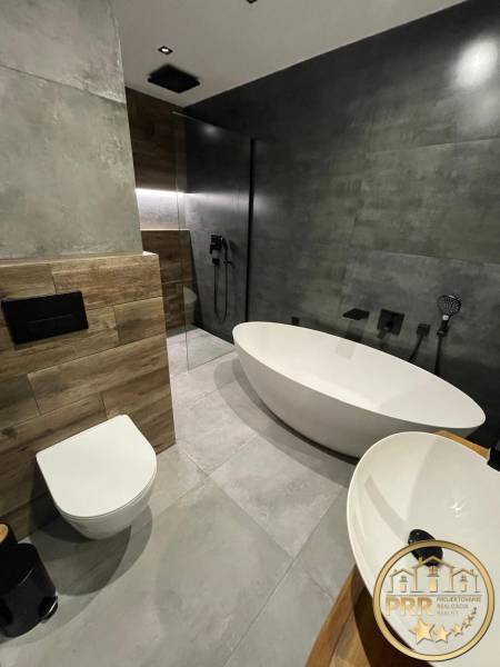 Badezimmer in einer 3-Zimmer-Wohnung mit freistehender Badewanne, Dusche und Waschbecken.