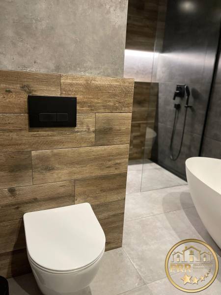 Badezimmer mit Dusche, Badewanne, Holzverkleidung in einer 3-Zimmer-Wohnung.