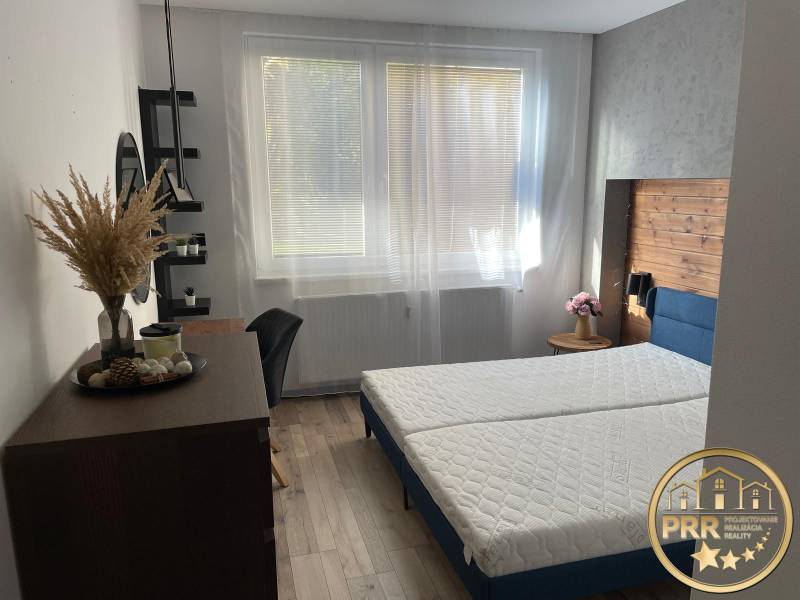 Helles Schlafzimmer in einer 3-Zimmer-Wohnung mit Bett und Holzelementen.